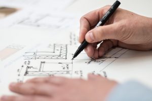 person-holding-black-pen-1109541 tafel bouwtekening